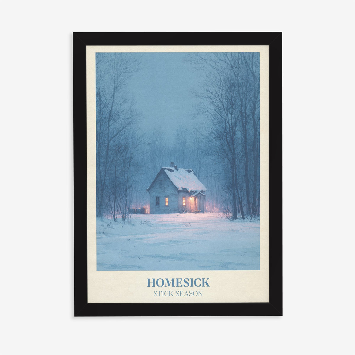 Homesick Noah Kahan print of a snowy cabin with glowing windows in a winter forest, in a black frame on a plain wall