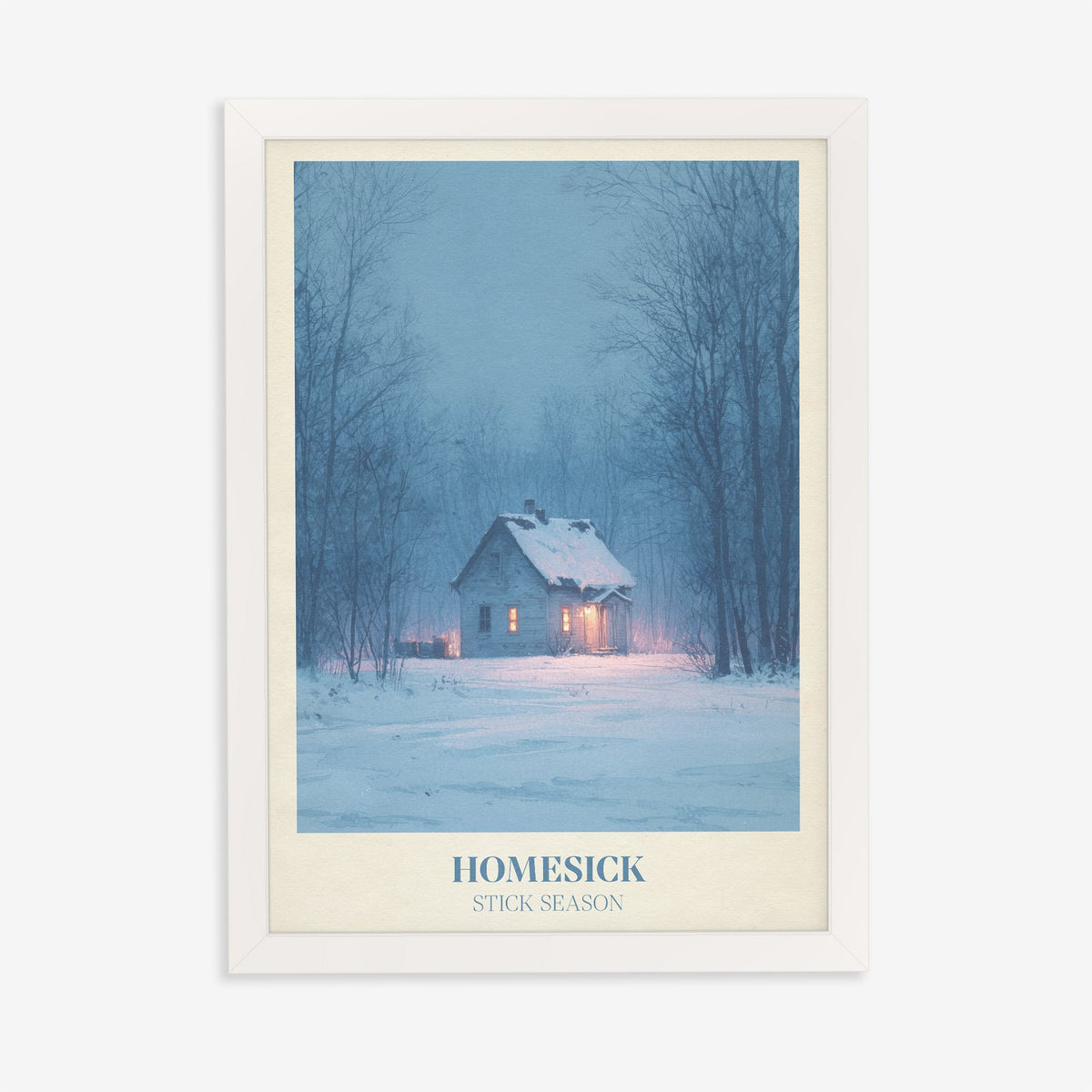 Homesick Noah Kahan print of a snowy cabin with glowing windows in a winter forest, in a white frame on a plain wall