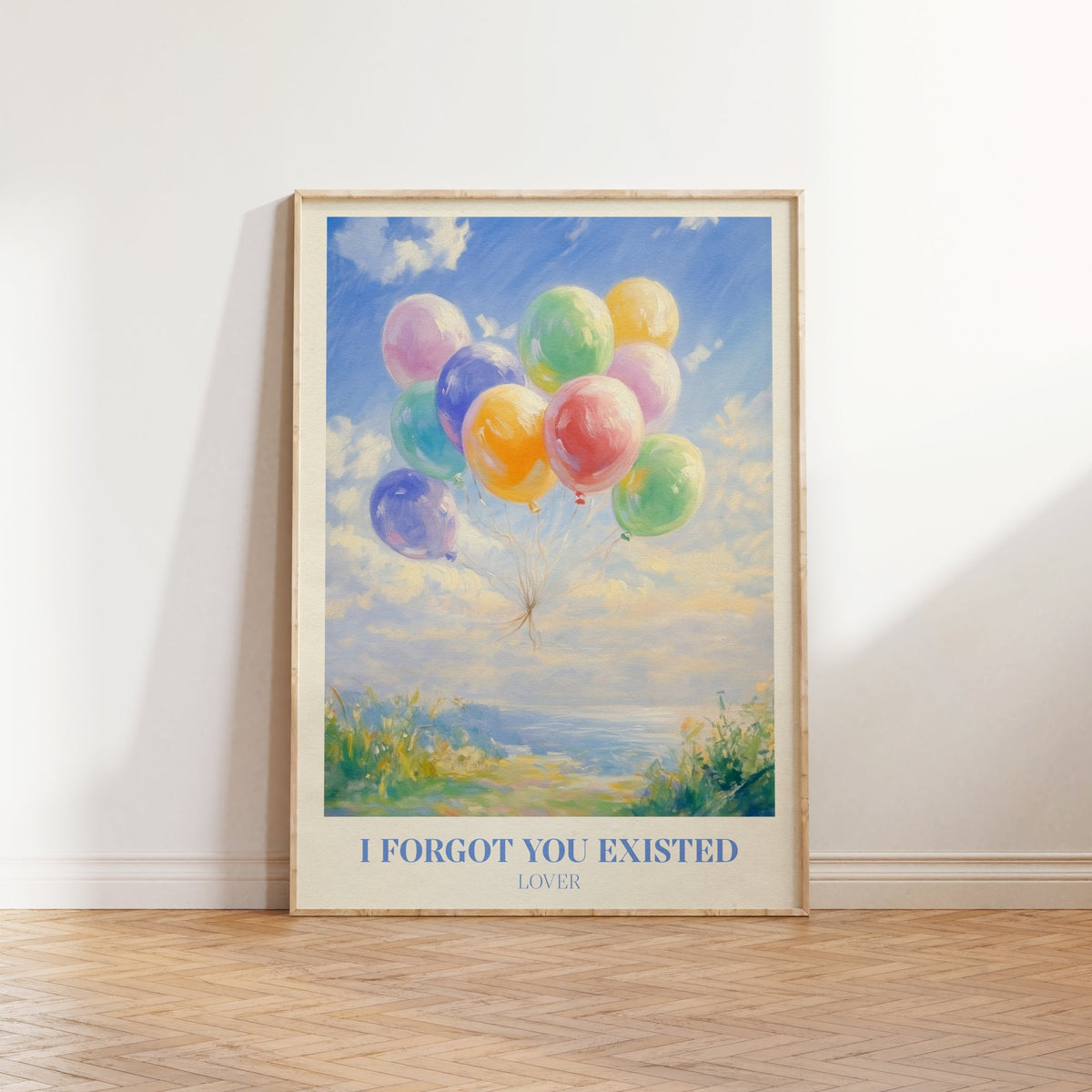 I Forgot You Existed Taylor Swift print of pastel balloons floating over the sea, framed, leaning against a white wall