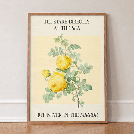 I Stare Directly At The Sun Taylor Swift lyric print of yellow roses and an Anti-Hero lyric, in an oak frame, leaning against a wall on a herringbone floor