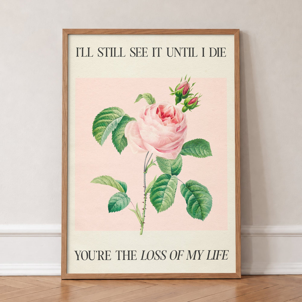 I’ll Still See It - LOML Taylor Swift print of a soft pink rose with rosebuds on blush pink, in an oak frame, leaning against a wall on a herringbone floor