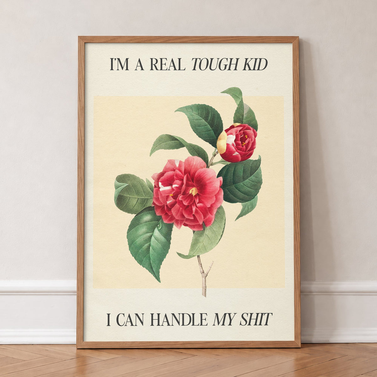 Im A Real Tough Kid I Can Handle My Shit Taylor Swift print of a red camellia on pale yellow, in an oak frame, leaning against a wall on a herringbone floor