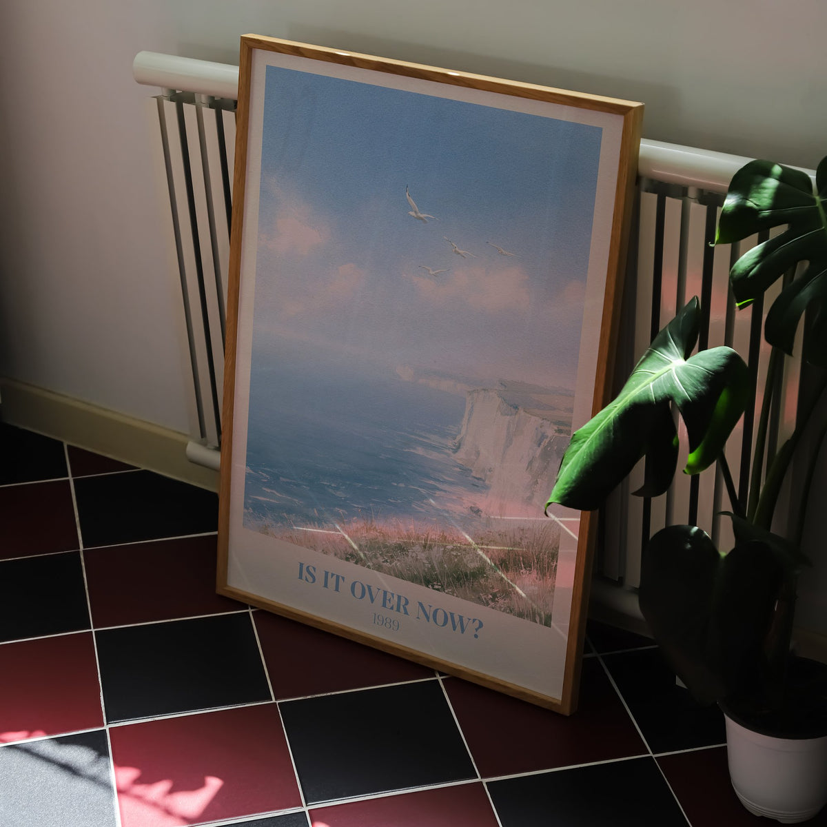 Is It Over Now? Taylor Swift print of white cliffs above a blue sea, on a kitchen floor with red and black tiles
