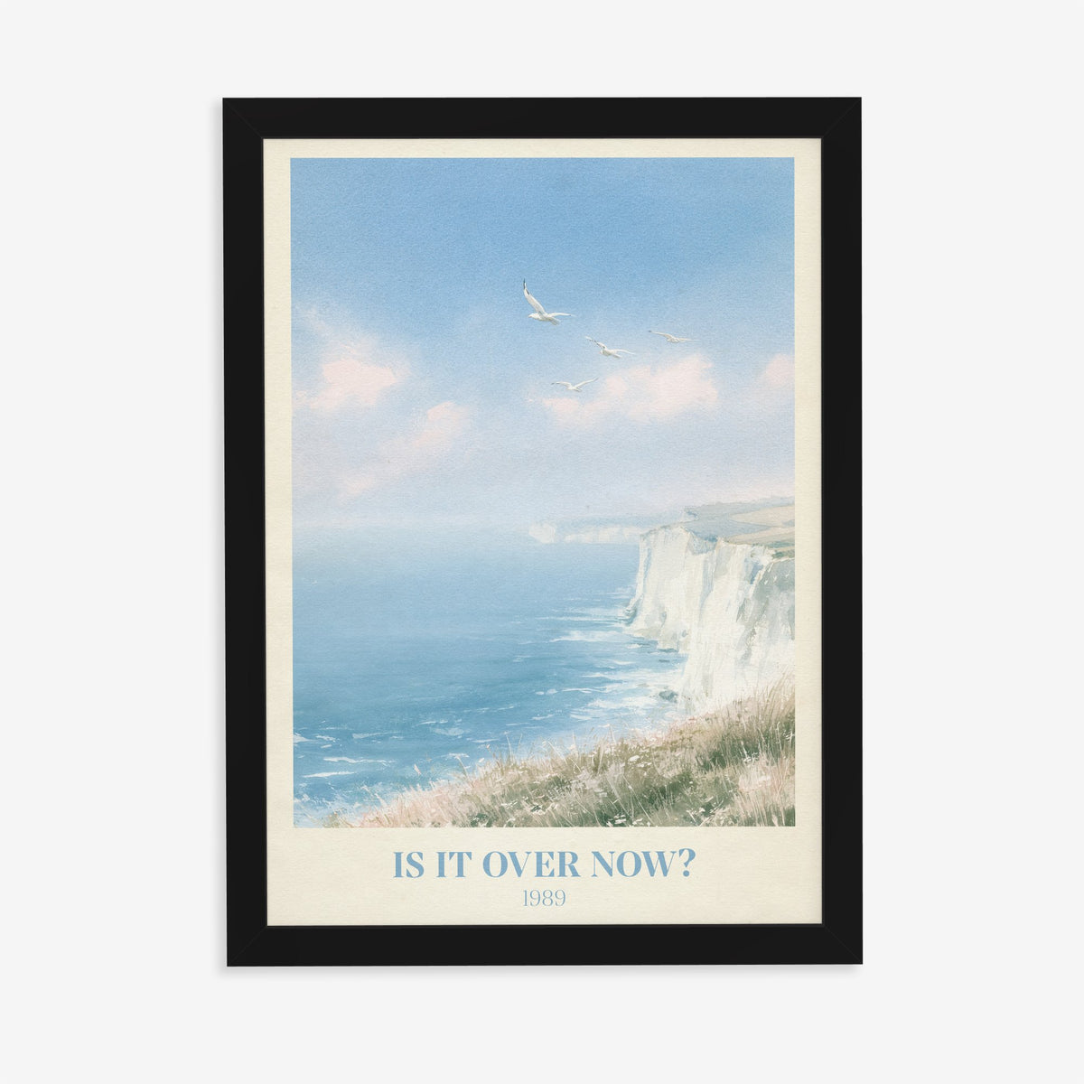 Is It Over Now? Taylor Swift print of white cliffs above a blue sea, in a black frame on a plain wall