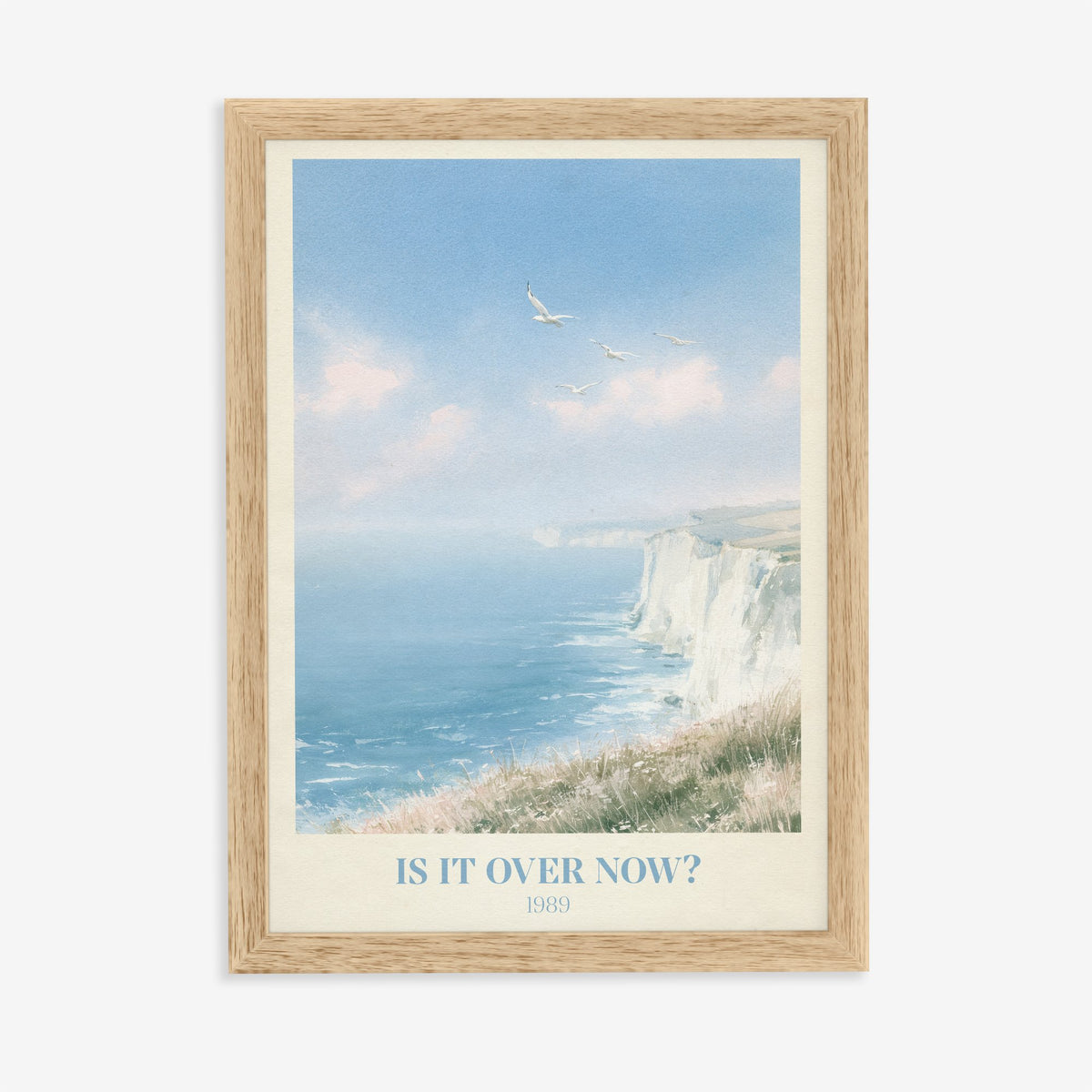 Is It Over Now? Taylor Swift print of white cliffs above a blue sea, in an oak frame on a plain wall