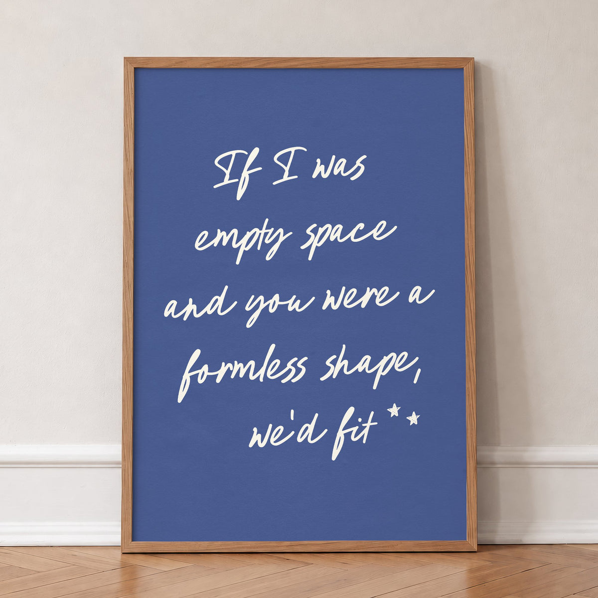 If I Was Empty Space Noah Kahan lyric print in cream handwriting on deep blue, in an oak frame, leaning against a wall on a herringbone floor