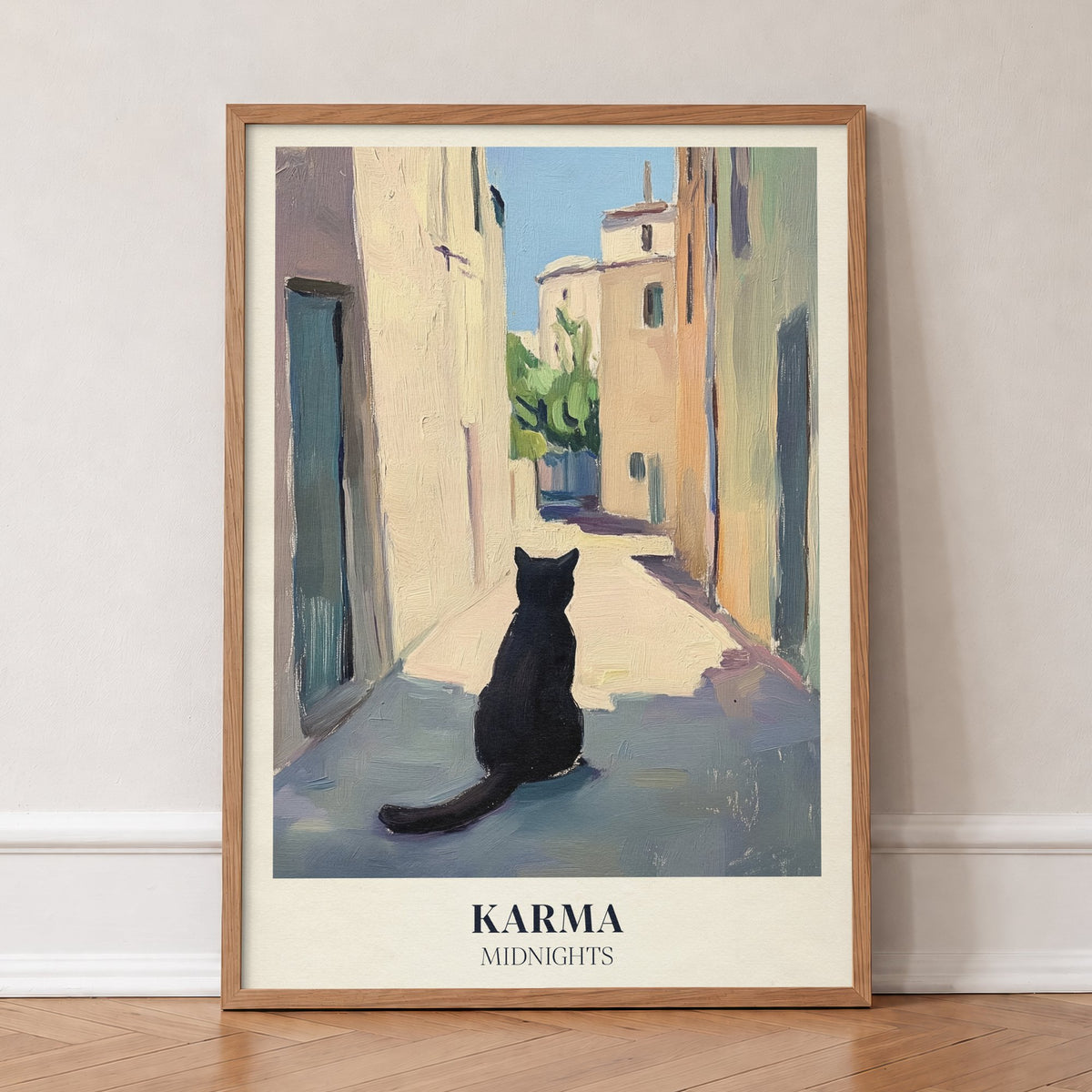 Karma Matisse Taylor Swift print of a black cat sitting in a sunny old-town street, in an oak frame, leaning against a wall on a herringbone floor