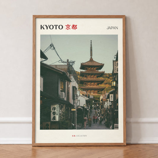 Kyoto travel print of the Yasaka Pagoda at the top of a narrow street of wooden shops, in an oak frame, leaning against a wall on a herringbone floor