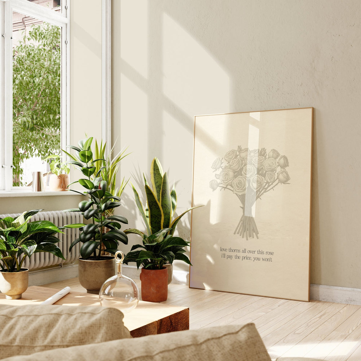 Love Thorns All Over Taylor Swift print of a sketched bunch of roses on cream paper, framed, leaning against a wall beside potted plants