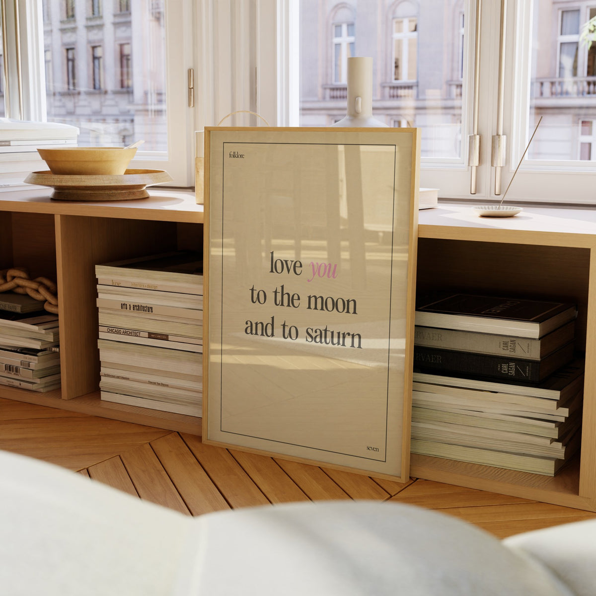 Love You To The Moon Taylor Swift print of the lyric in black and pink type on cream, framed on a bookcase by a window