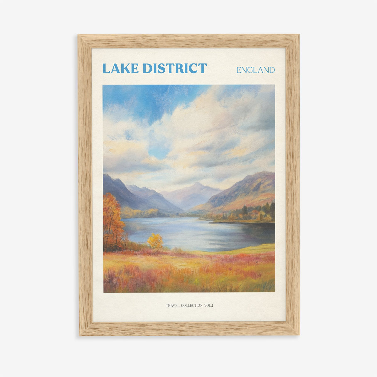 Lake District travel print of a lake between mountains under big clouds, with orange autumn grass, in an oak frame on a plain wall