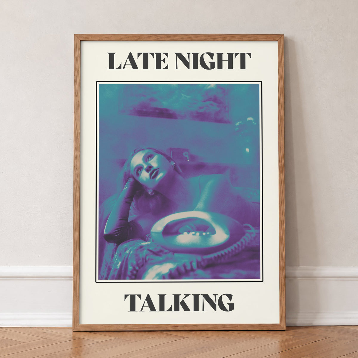 Late Night Talking Harry Styles print of a retro purple and teal phone photo, in an oak frame, leaning against a wall on a herringbone floor