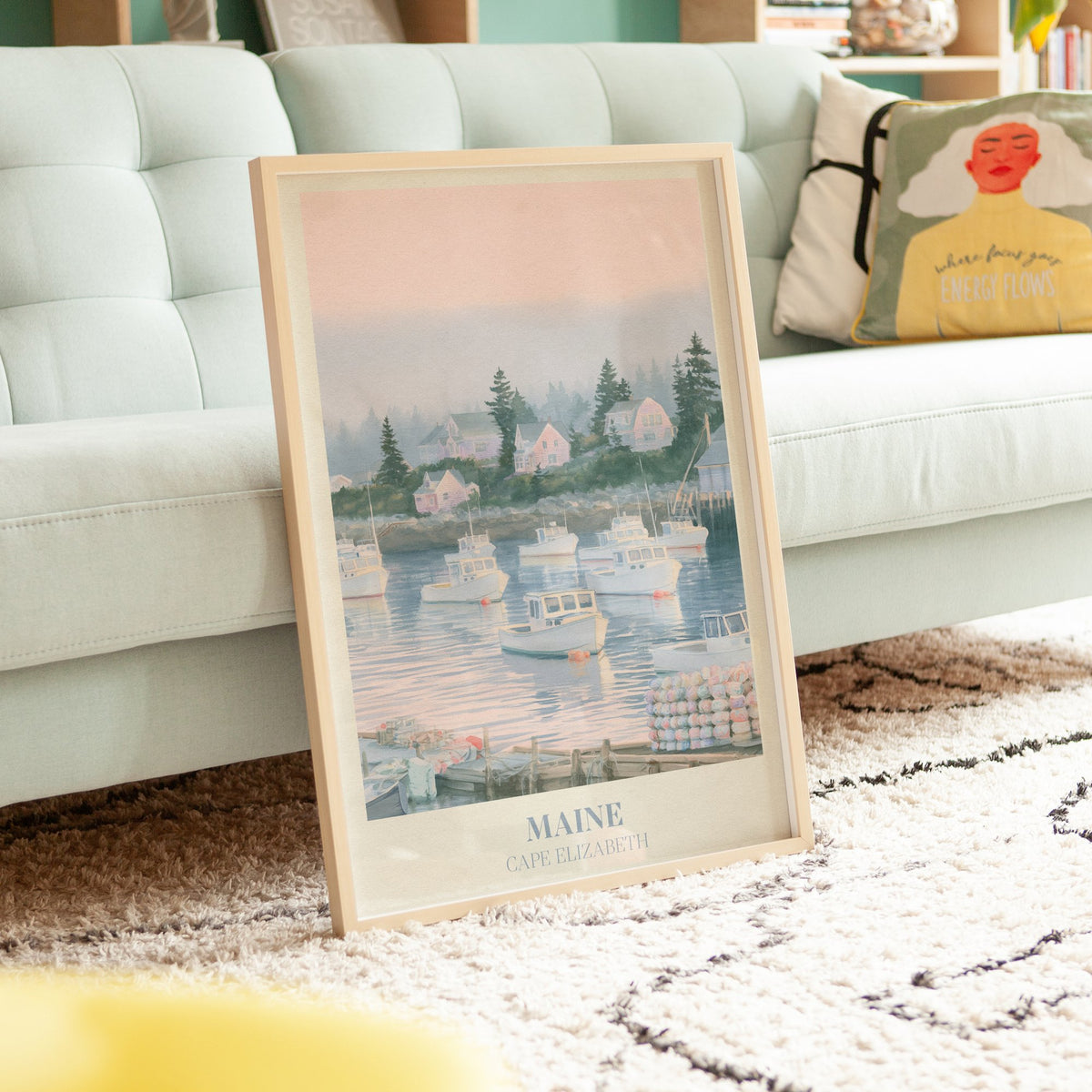 Maine Noah Kahan print of lobster boats in a misty pink harbour, leaning on a rug beside a mint sofa