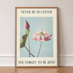 Never Be So Clever Taylor Swift print of a pink lotus on pale blue between lines of lyric, in an oak frame, leaning against a wall on a herringbone floor