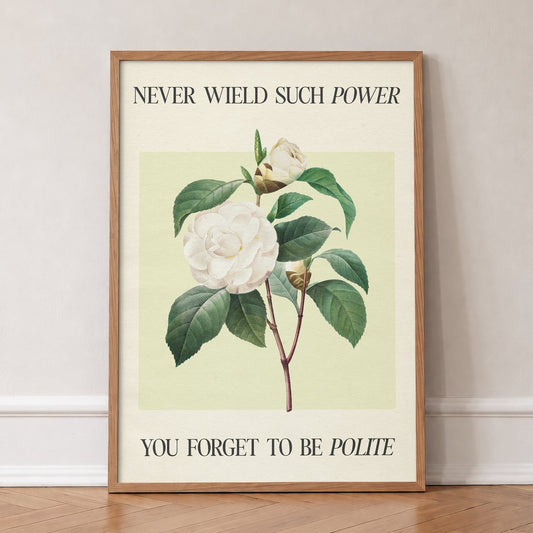 Never Wield Such Power Camellia Taylor Swift print of a white camellia between lines of lyric, in an oak frame, leaning against a wall on a herringbone floor