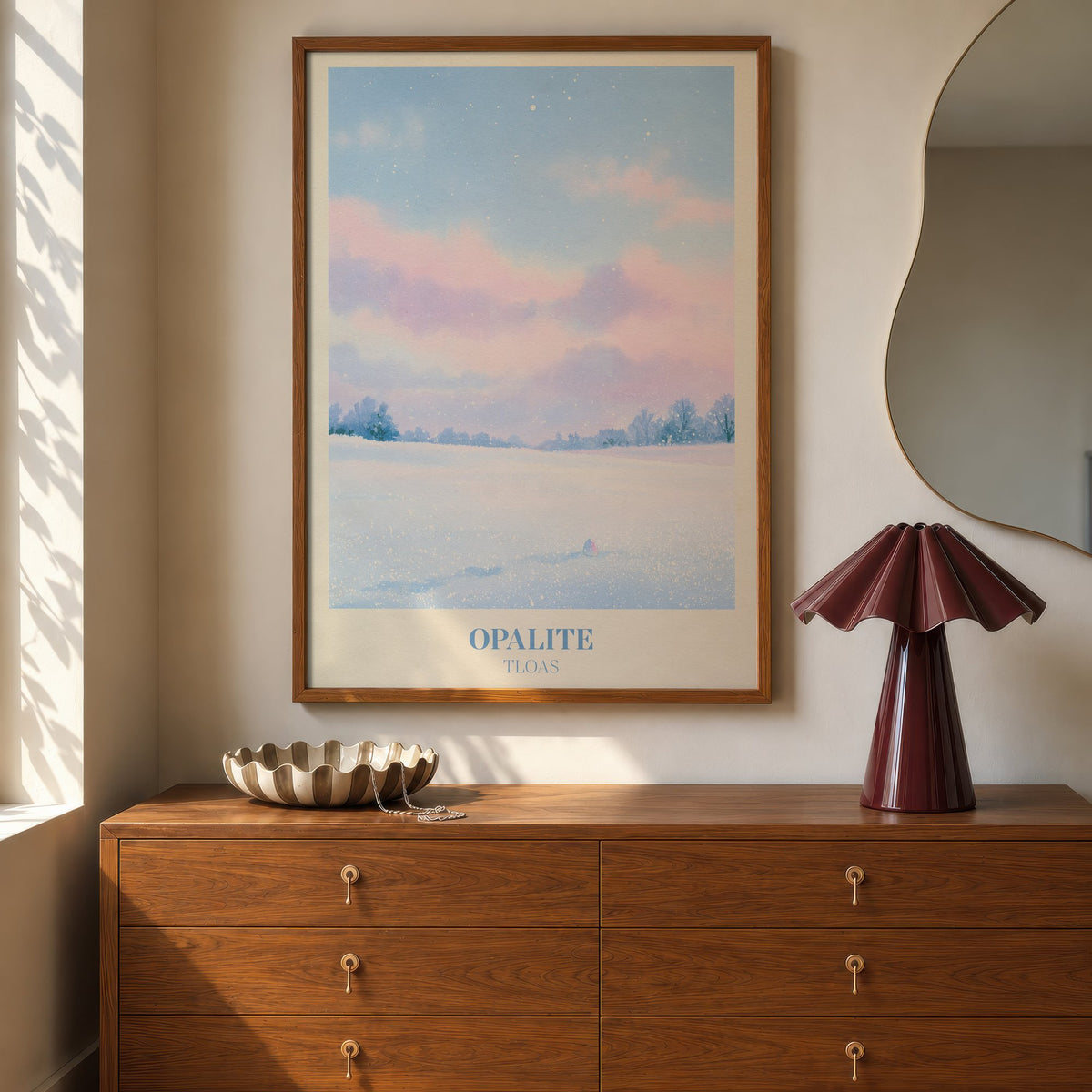Opalite Winter Taylor Swift print of pink clouds over a snowy field, hung above a walnut dresser beside a wavy mirror and a pleated lamp