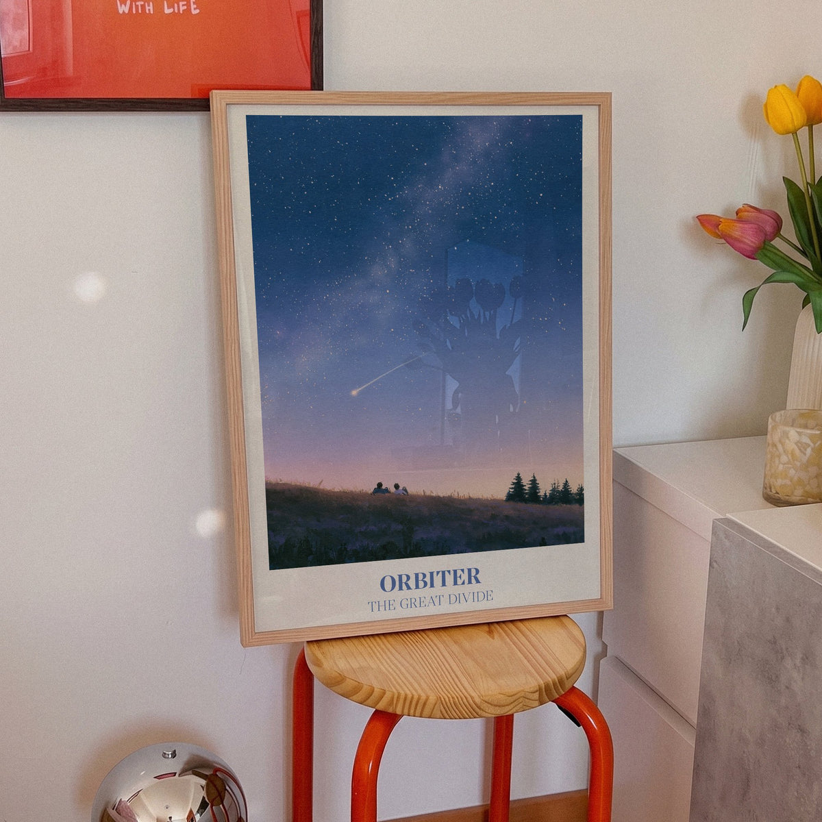 Orbiter Noah Kahan print of two people watching a shooting star from a hillside, on an orange stool beside tulips