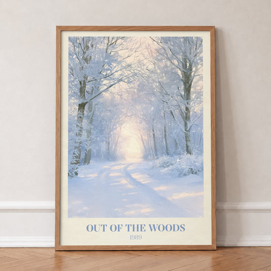 Out Of The Woods Winter Taylor Swift print of a snowy woodland path, in an oak frame, leaning against a wall on a herringbone floor
