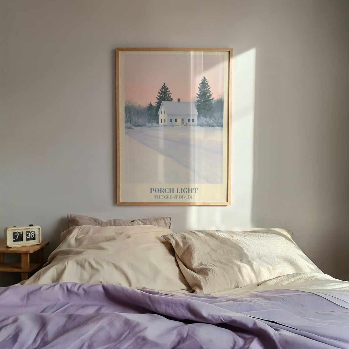 Porch Light Noah Kahan print of a snowy farmhouse, porch light on, framed above a bed with lilac bedding