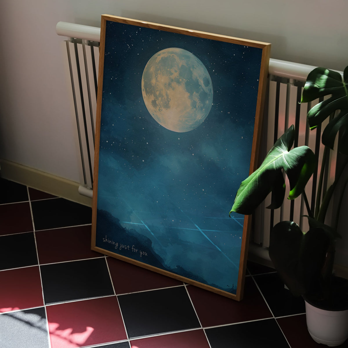 Shining Just For You Taylor Swift print of a full moon over a starry blue night sky, framed, leaning against a radiator