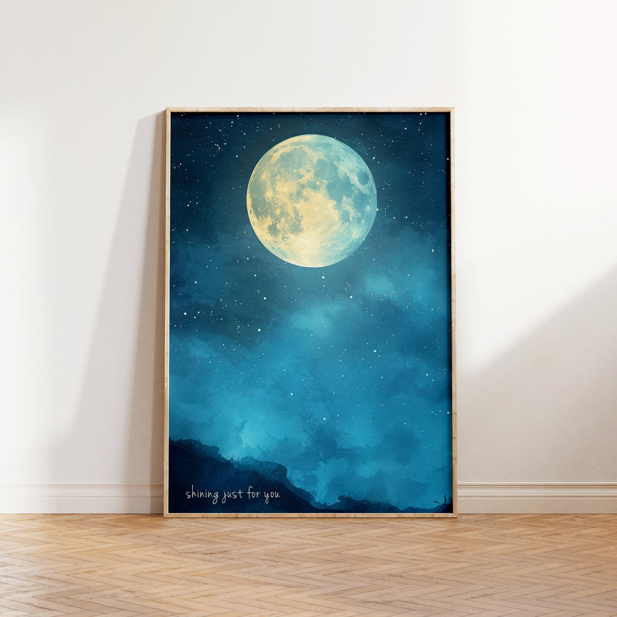 Shining Just For You Taylor Swift print of a full moon over a starry blue night sky, framed, leaning against a white wall