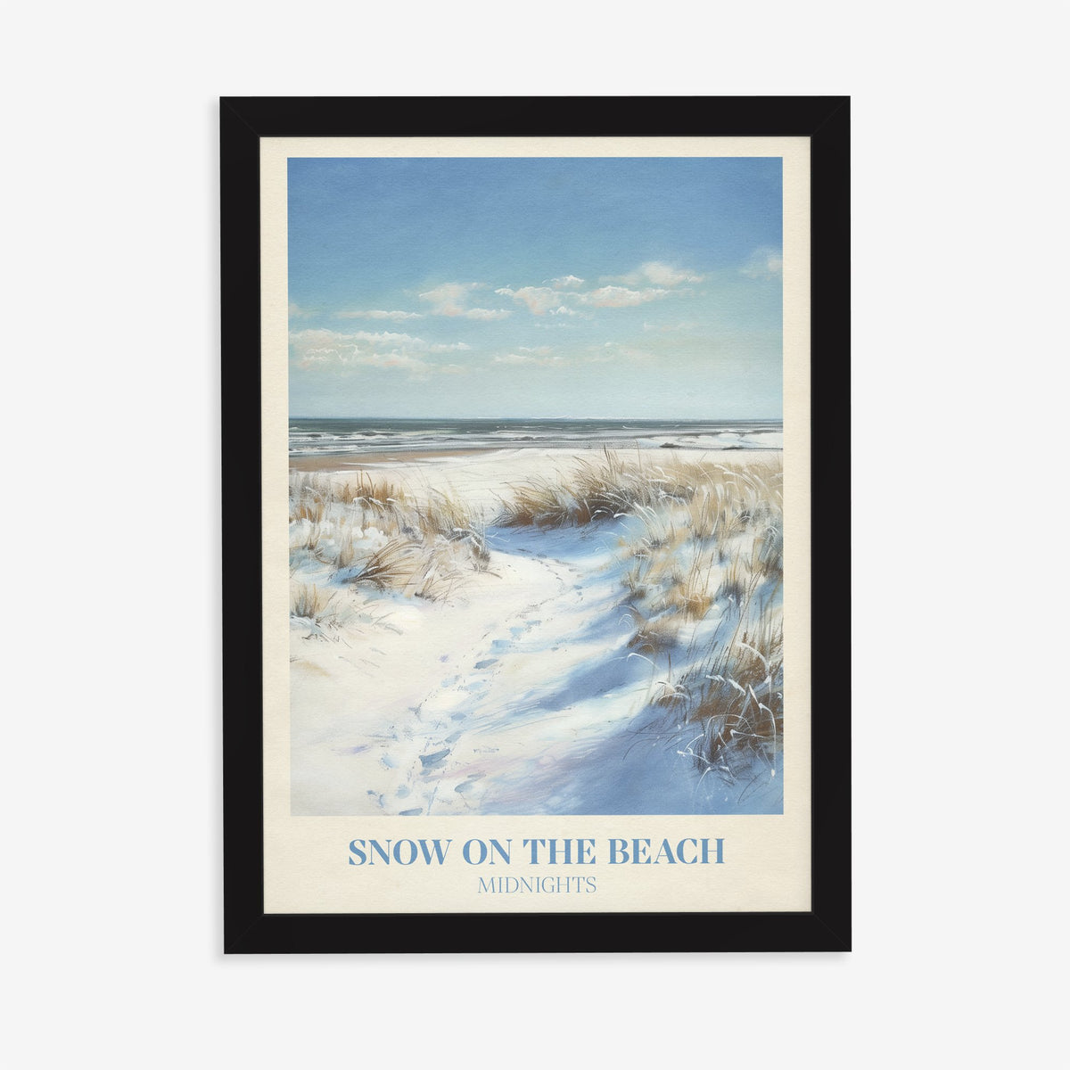 Snow On The Beach Taylor Swift print of snowy sand dunes and beach grass beside a blue sea, in a black frame on a plain wall