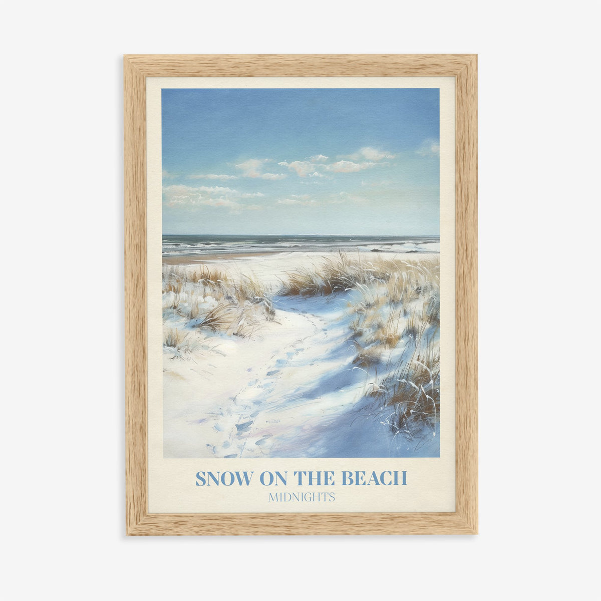 Snow On The Beach Taylor Swift print of snowy sand dunes and beach grass beside a blue sea, in an oak frame on a plain wall