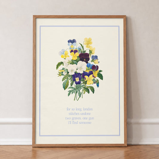 So Long London Floral Taylor Swift print of a posy of purple and yellow pansies in a blue border, in an oak frame, leaning against a wall on a herringbone floor
