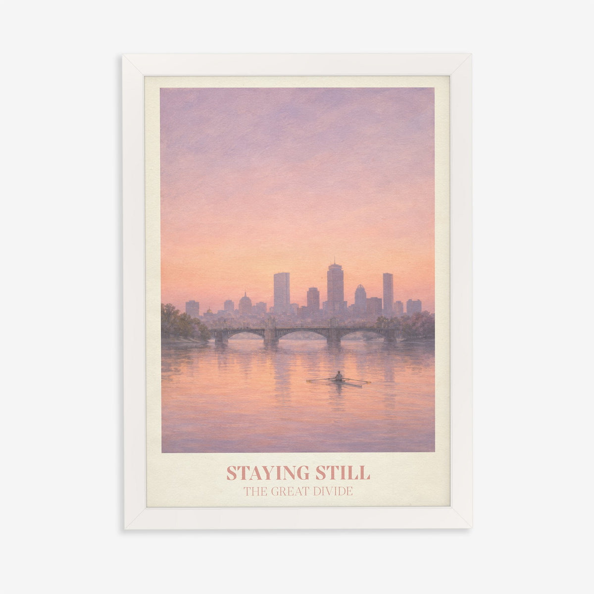 Staying Still Noah Kahan print of a lone rower on a pink river below a city skyline, in a white frame on a plain wall