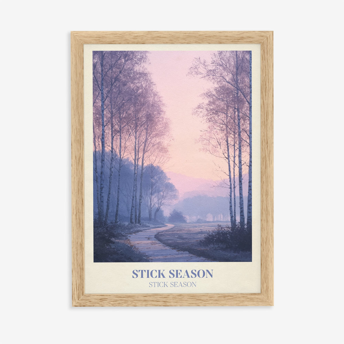Stick Season Noah Kahan print of a misty path through bare birch trees under a pink sky, in an oak frame on a plain wall