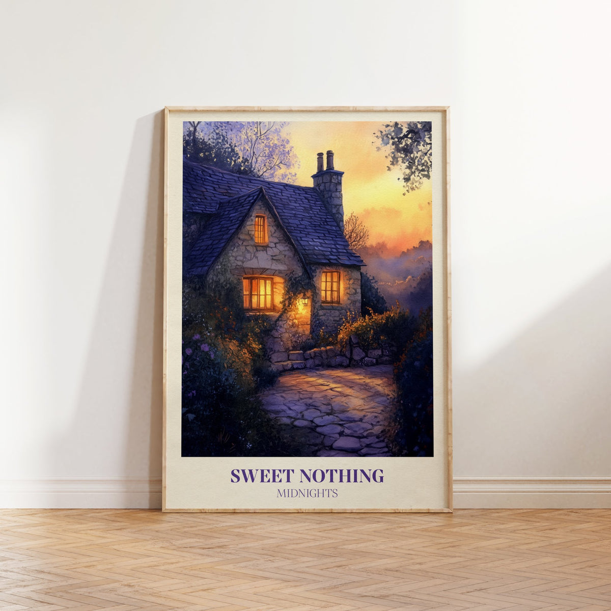 Sweet Nothing Evening Cottage Taylor Swift print of a stone cottage with glowing windows at dusk, framed, leaning against a white wall