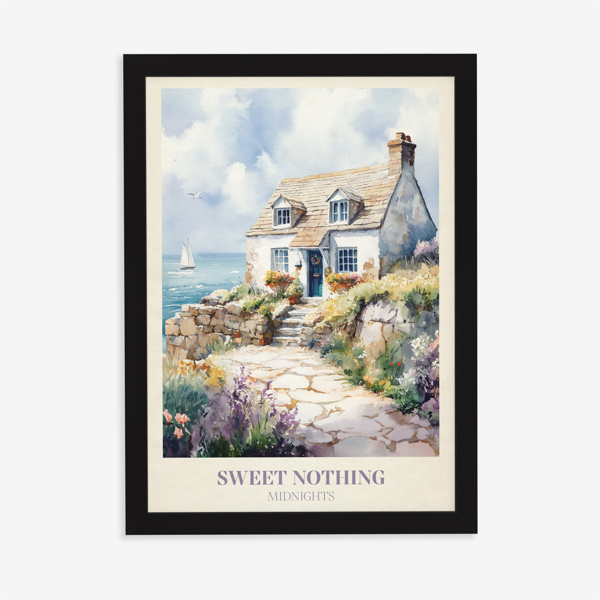 Sweet Nothing Taylor Swift print of a white seaside cottage with a stone path and wildflowers, in a black frame on a plain wall