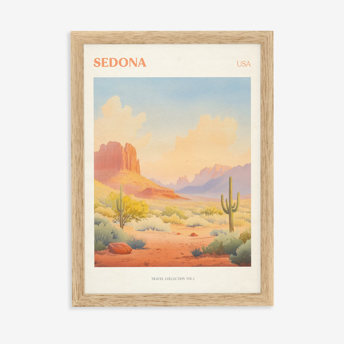 Sedona travel print of red rock formations and tall cacti under a peach desert sky, in an oak frame on a plain wall