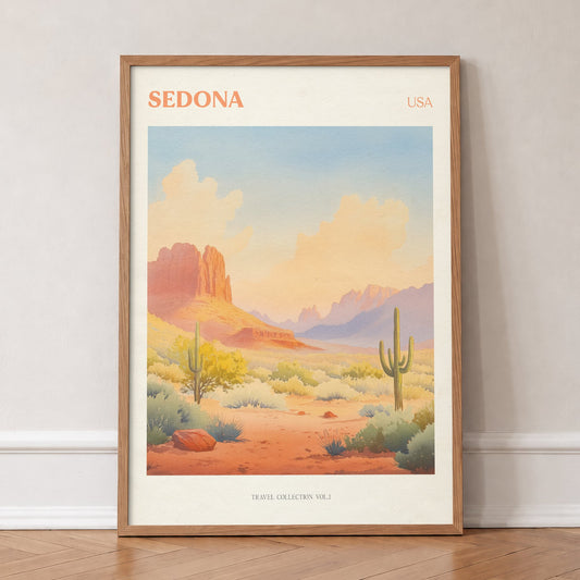 Sedona travel print of red rock formations and tall cacti under a peach desert sky, in an oak frame, leaning against a wall on a herringbone floor