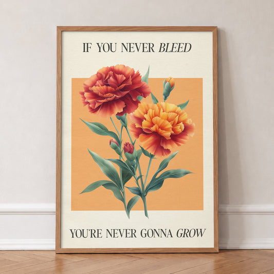 The 1 Botanical Taylor Swift print of red and orange carnations on a peach square, in an oak frame, leaning against a wall on a herringbone floor