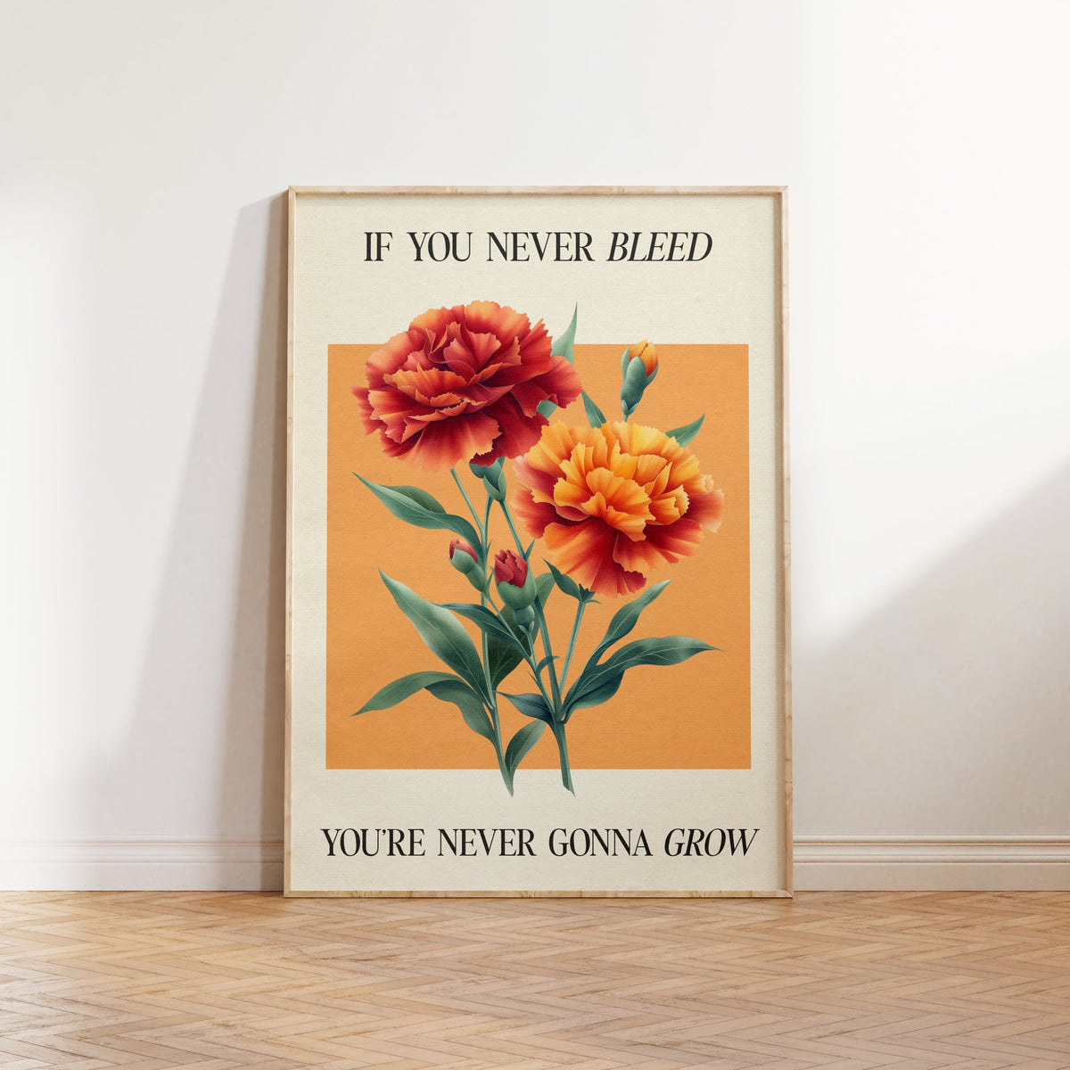 The 1 Botanical Taylor Swift print of red and orange carnations on a peach square, framed, leaning against a white wall