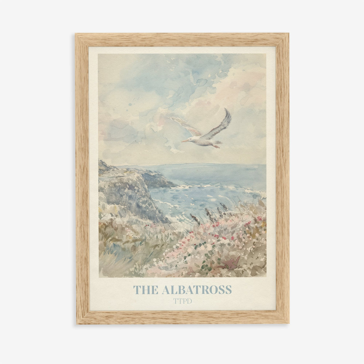 The Albatross Taylor Swift print of a seabird over a clifftop of pink wildflowers, in an oak frame on a plain wall