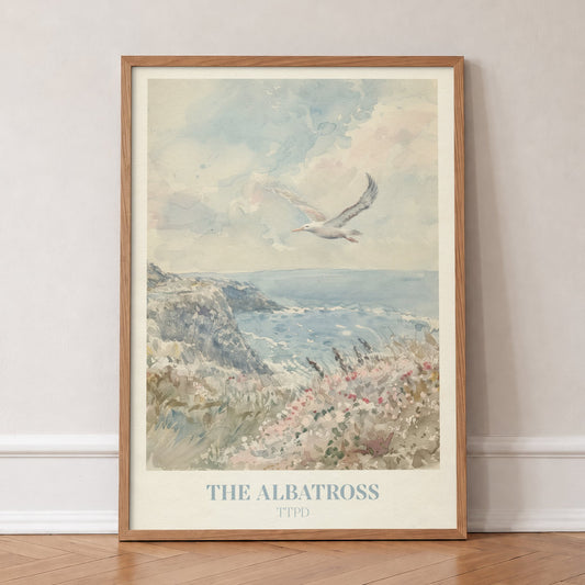 The Albatross Taylor Swift print of a seabird over a clifftop of pink wildflowers, in an oak frame, leaning against a wall on a herringbone floor
