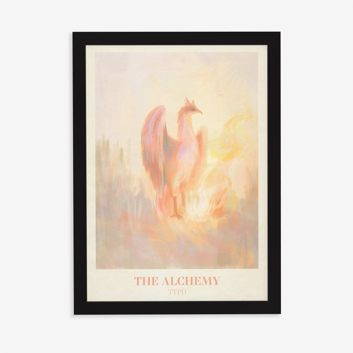 The Alchemy Taylor Swift print of a pink and peach phoenix rising beside golden flames, in a black frame on a plain wall