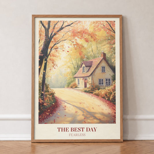 The Best Day Taylor Swift print of a cottage on a leafy autumn lane, in an oak frame, leaning against a wall on a herringbone floor