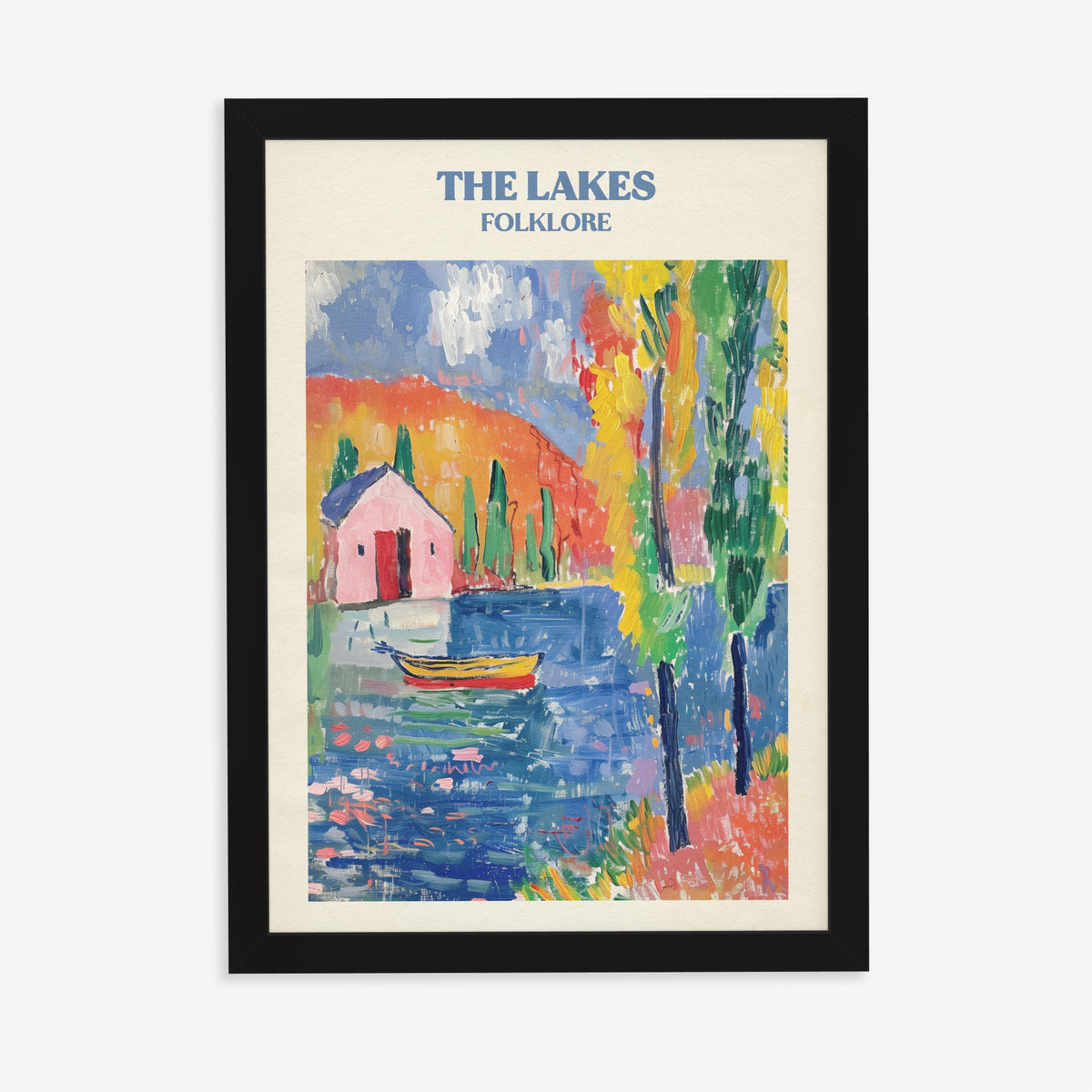 The Lakes Matisse Taylor Swift print of a pink cottage and a boat on a bright blue lake, in a black frame on a plain wall