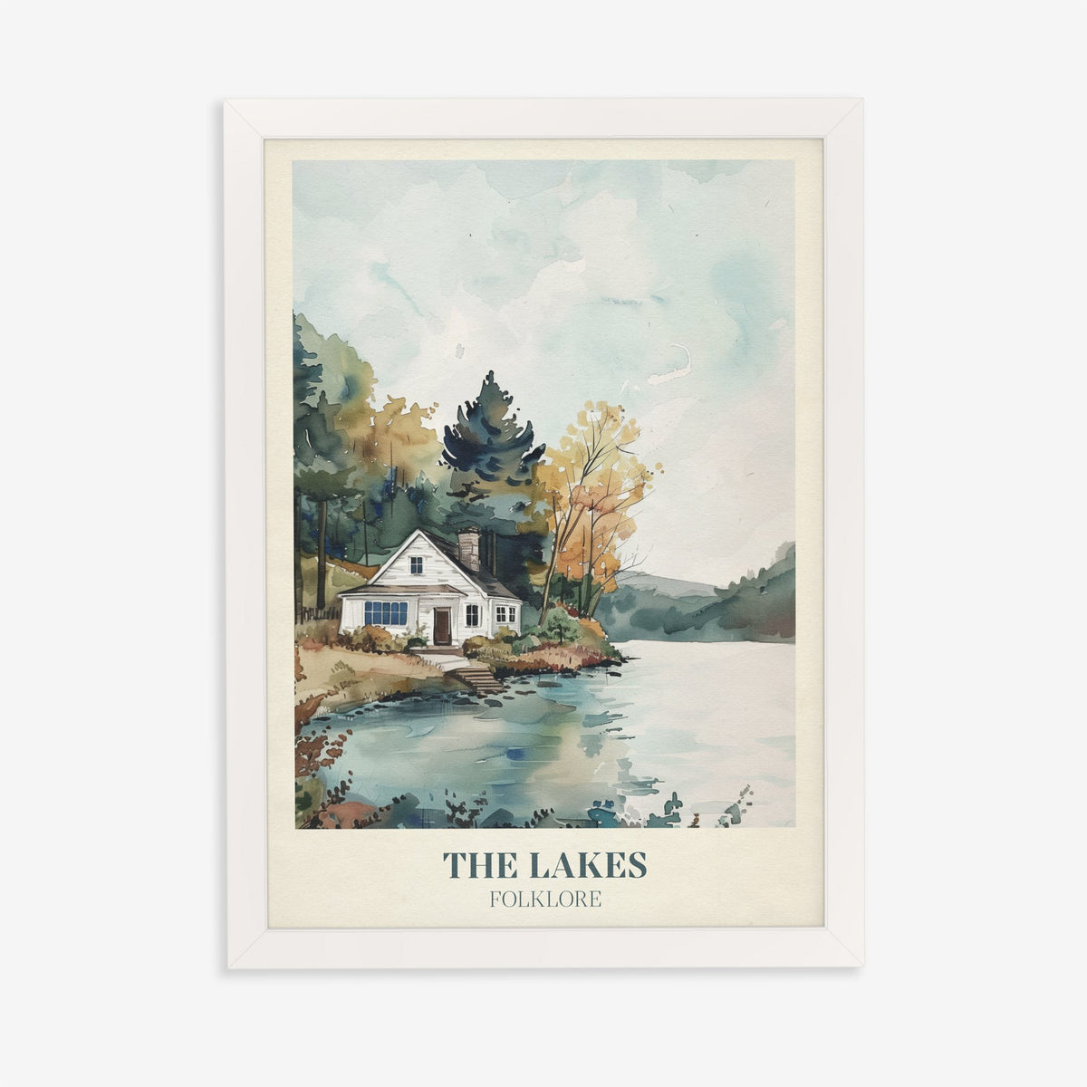 The Lakes Taylor Swift print of a white cottage beside a still lake and trees, in a white frame on a plain wall