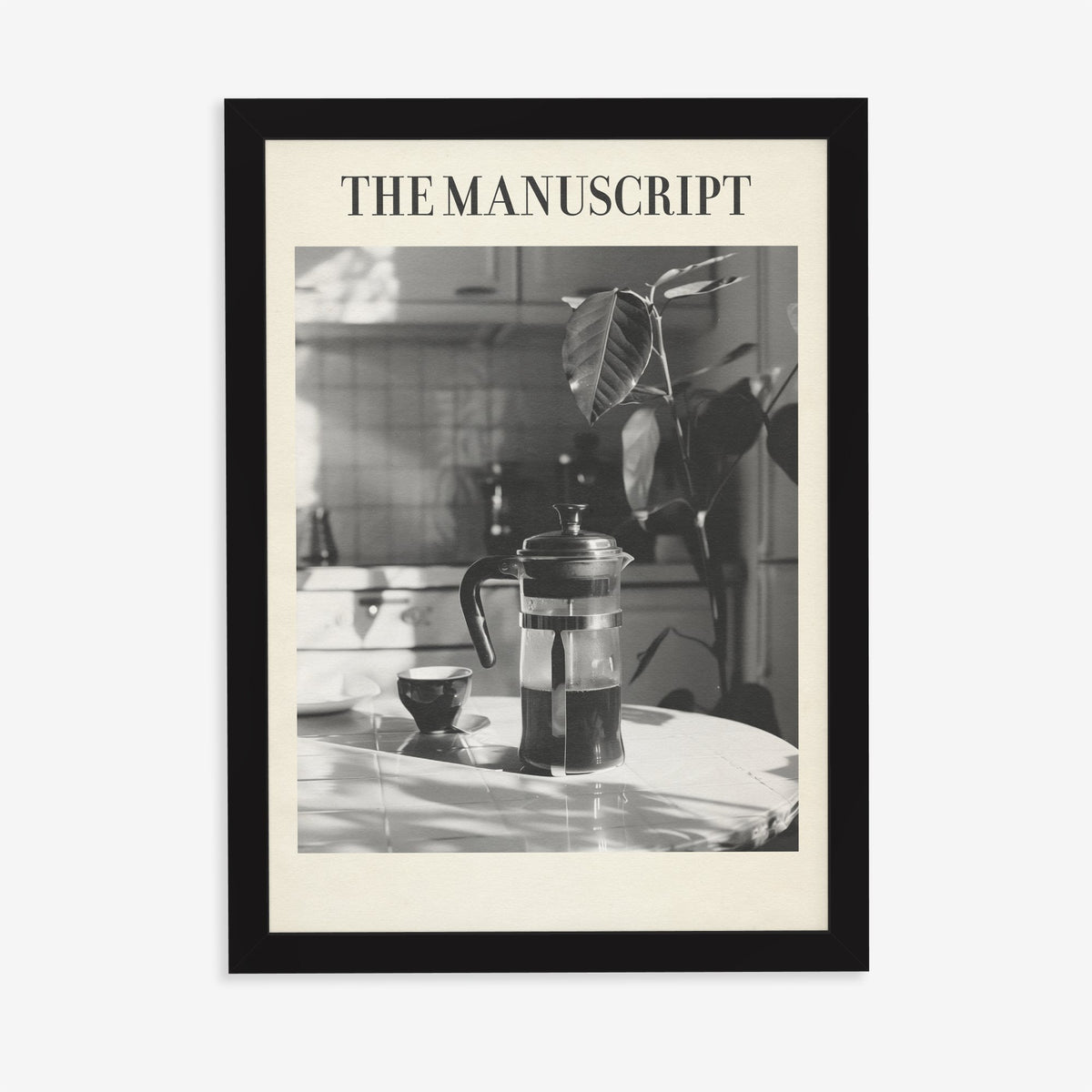 The Manuscript Taylor Swift print of a black and white French press and cup on a sunlit table, in a black frame on a plain wall