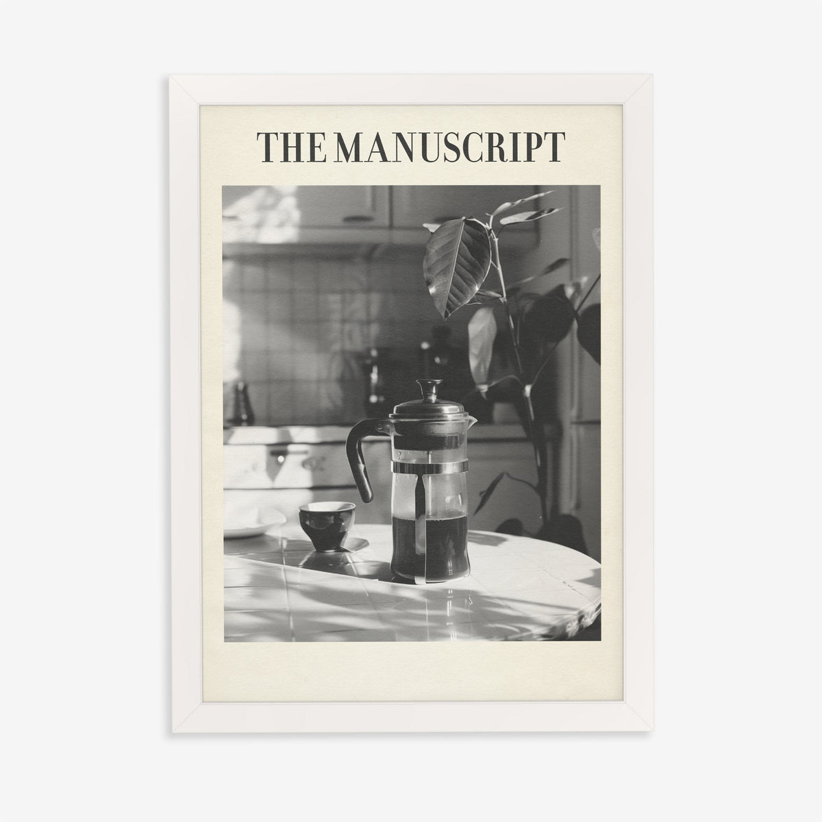 The Manuscript Taylor Swift print of a black and white French press and cup on a sunlit table, in a white frame on a plain wall