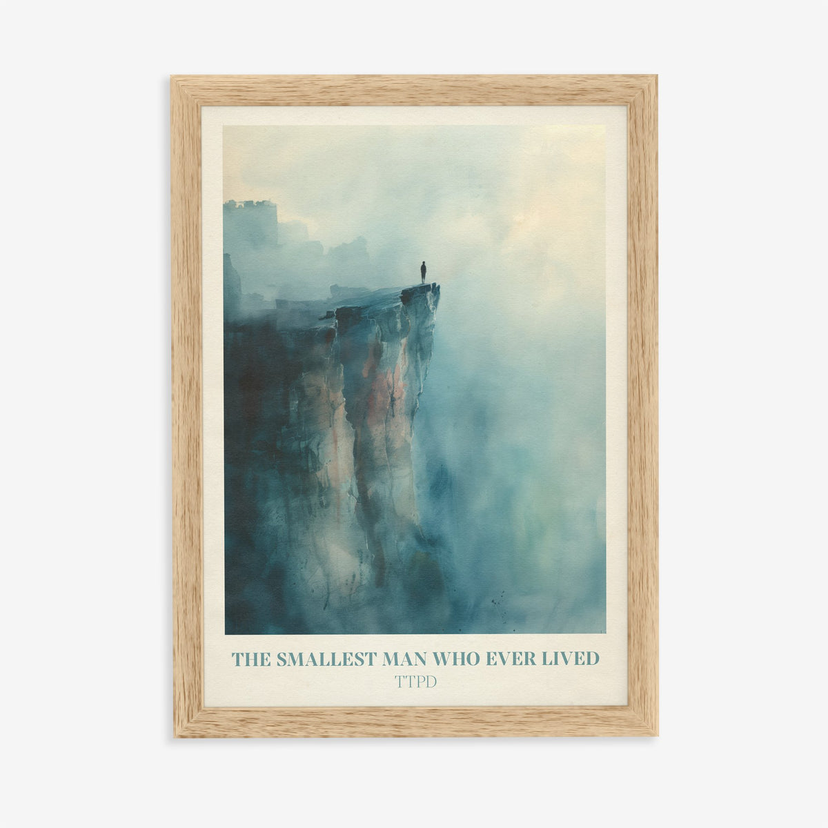 The Smallest Man Who Ever Lived Taylor Swift print of a lone figure on a misty blue cliff, in an oak frame on a plain wall