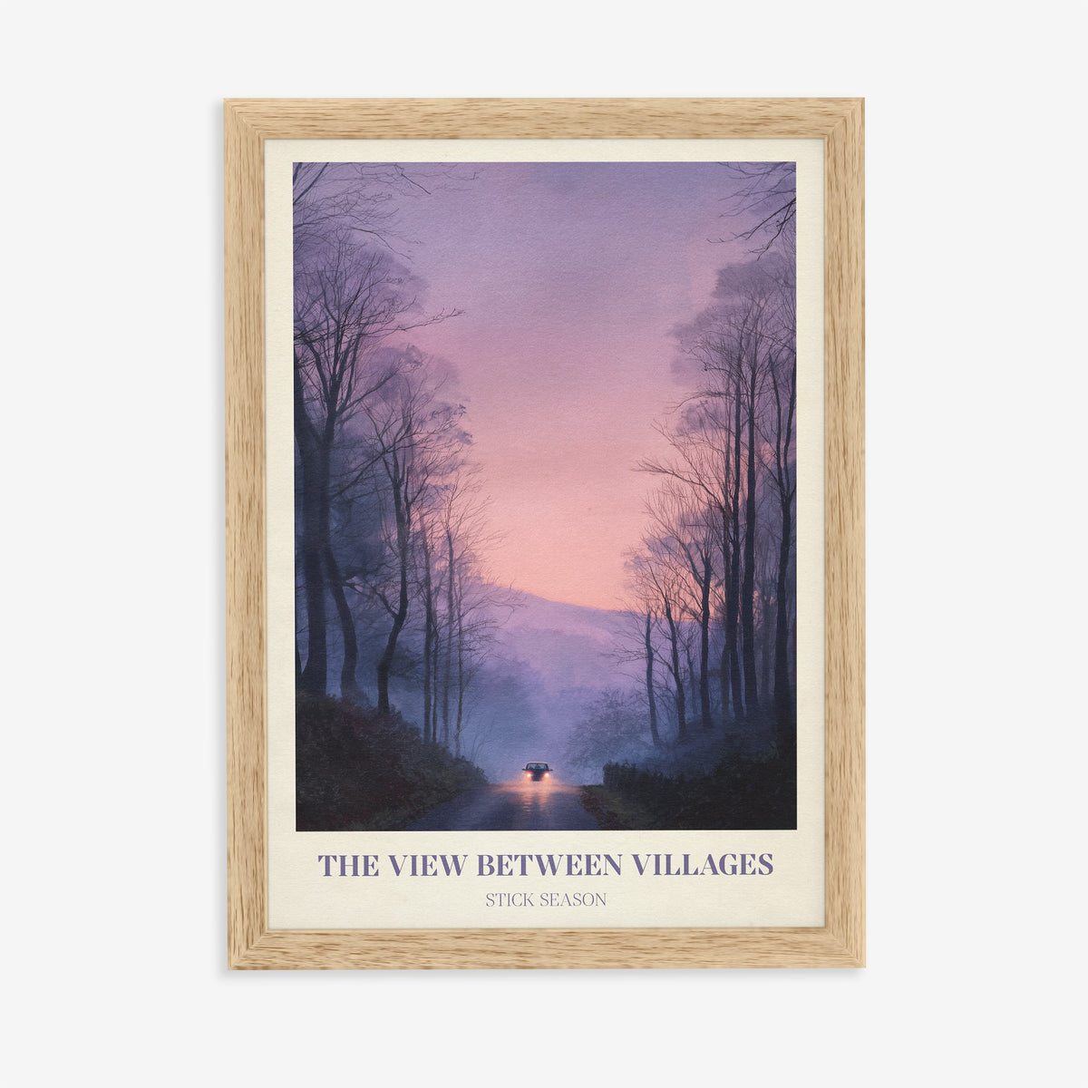 The View Between Villages Noah Kahan print of headlights on a misty road through purple trees, in an oak frame on a plain wall