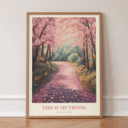 This Is Me Trying Taylor Swift print of a winding path under pink blossom trees, in an oak frame, leaning against a wall on a herringbone floor