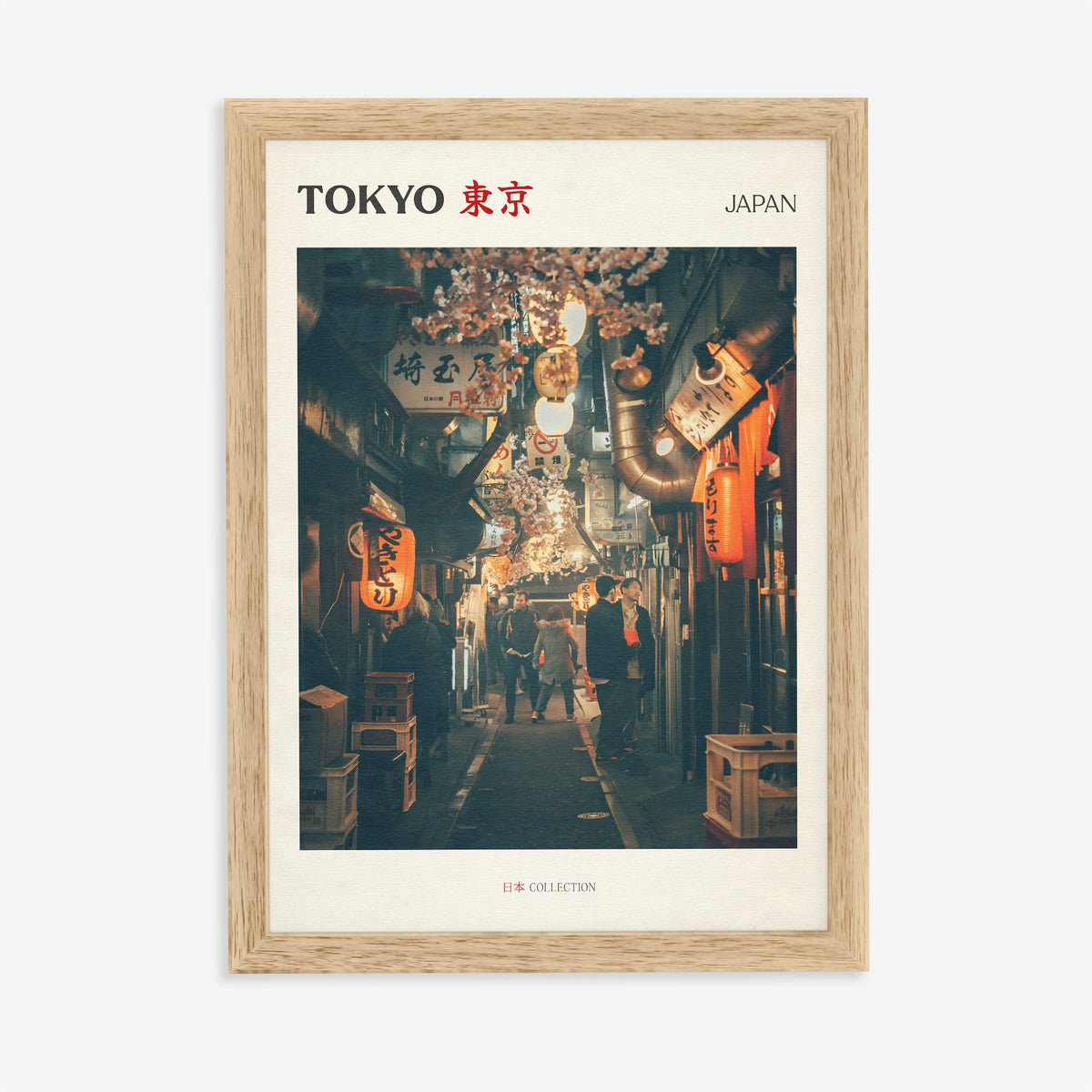 Tokyo travel print of a narrow side street at night lit by red paper lanterns, in an oak frame on a plain wall