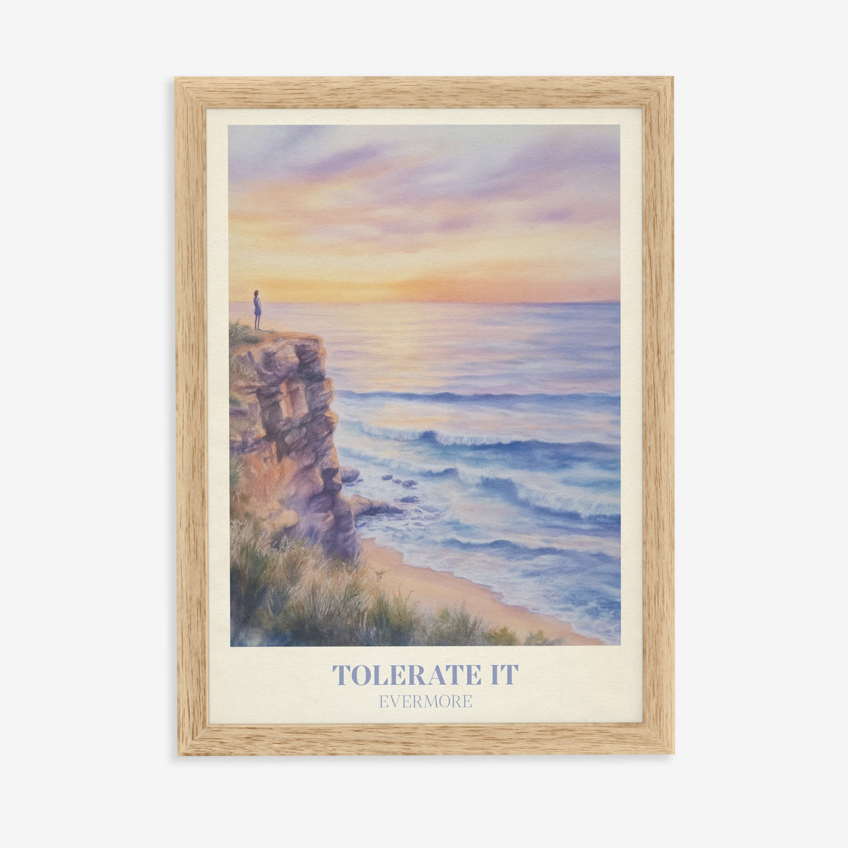 Tolerate It Taylor Swift print of a lone figure on a clifftop above a lilac sunset sea, in an oak frame on a plain wall