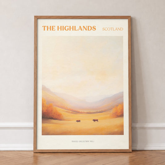 Highlands travel print of a golden autumn glen with two Highland cows under a soft peach sky, in an oak frame, leaning against a wall on a herringbone floor